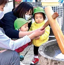 保育園の玄関前で餅つき