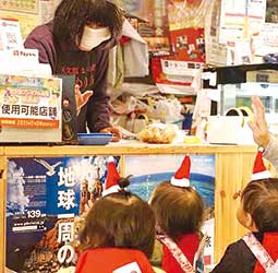 クリスマスに近所のお店にプレゼントを配る子どもたち