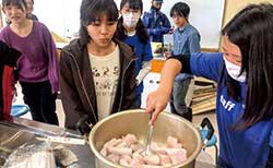 家庭科室にて、漁師を講師に招いた調理実習を行っている
