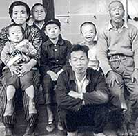 2歳のころ。左端で母に抱っこされているのが私。築100年以上経っていた自宅の縁側での家族写真。これが私の原点