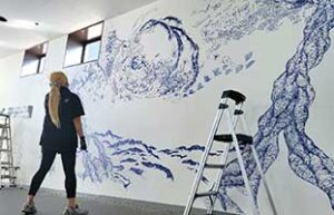 壁一面に青一色でペンで絵を描く