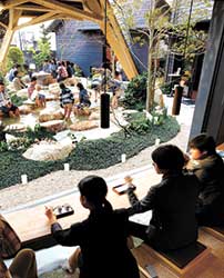 2015年に完成した湯田温泉観光回遊拠点施設「狐の足あと」。 四季折々の自然の彩りや石組みの力強さを体感できる「四季の湯」（=写真奥）。「窓辺の湯」（=写真手前）では、「四季の湯」を眺めつつ、カフェの飲み物やスイーツが楽しめる［撮影：黒住直臣］　