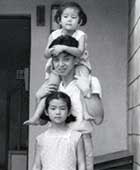 父・佐知夫、妹・由里江と共に。東京都世田谷区の自宅玄関前にて
