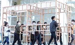 カドウ建築の宴 in OPAMで、「はしごマルシェ」を会場である道路へと運搬するスタッフや学生