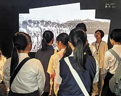 広島の復興の物語を伝える常設展示「Pride of Hiroshima」で中高生を案内する通訳案内士や大学生