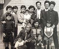 1958年、4歳の頃。大阪にあった母の実家にて。前列右から2番目で座っているのが本人。後列左から3番目が母で、抱えているのは4つ下の妹