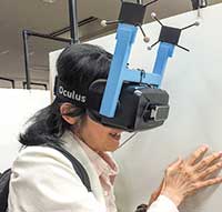東京大学大学院の廣瀬・谷川・鳴海研究室とUnityの簗瀬洋平氏が制作した、高所にある足場を歩き回るVRシステムUnlimited Corridor（無限回廊）を体験しているところ 。高所を歩く怖さに必死に耐えている