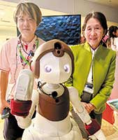 日本科学未来館にて。ソニーグループ　ハナモフロルプロジェクトリーダーの袖山慶直氏と。中央が子ども型見守り介護ロボット「ハナモフロル」（2023年の第11回かわいい感性デザイン賞最優秀賞）